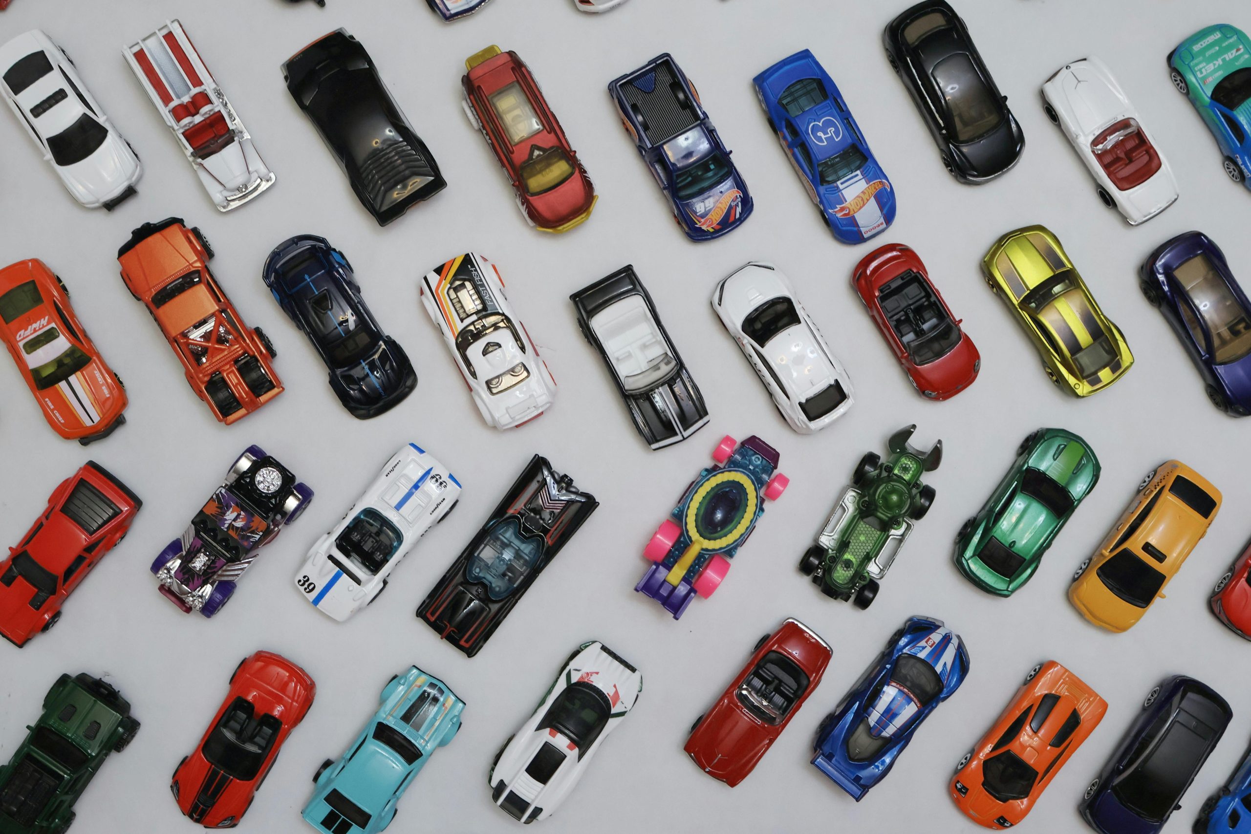 A vibrant assortment of toy cars arranged on a white background, viewed from above.