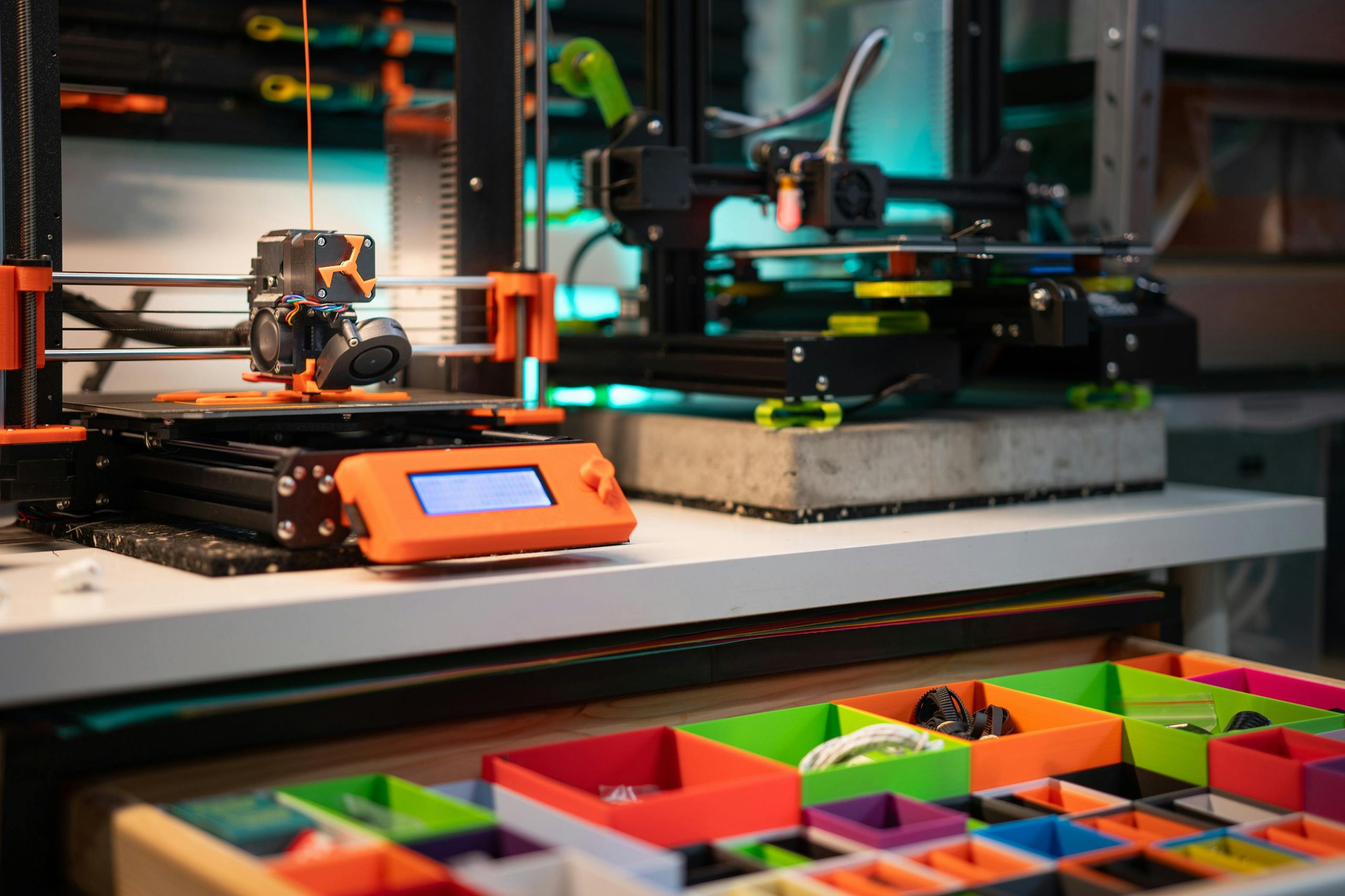 Vibrant 3D printing station showcasing modern equipment and organized storage boxes.