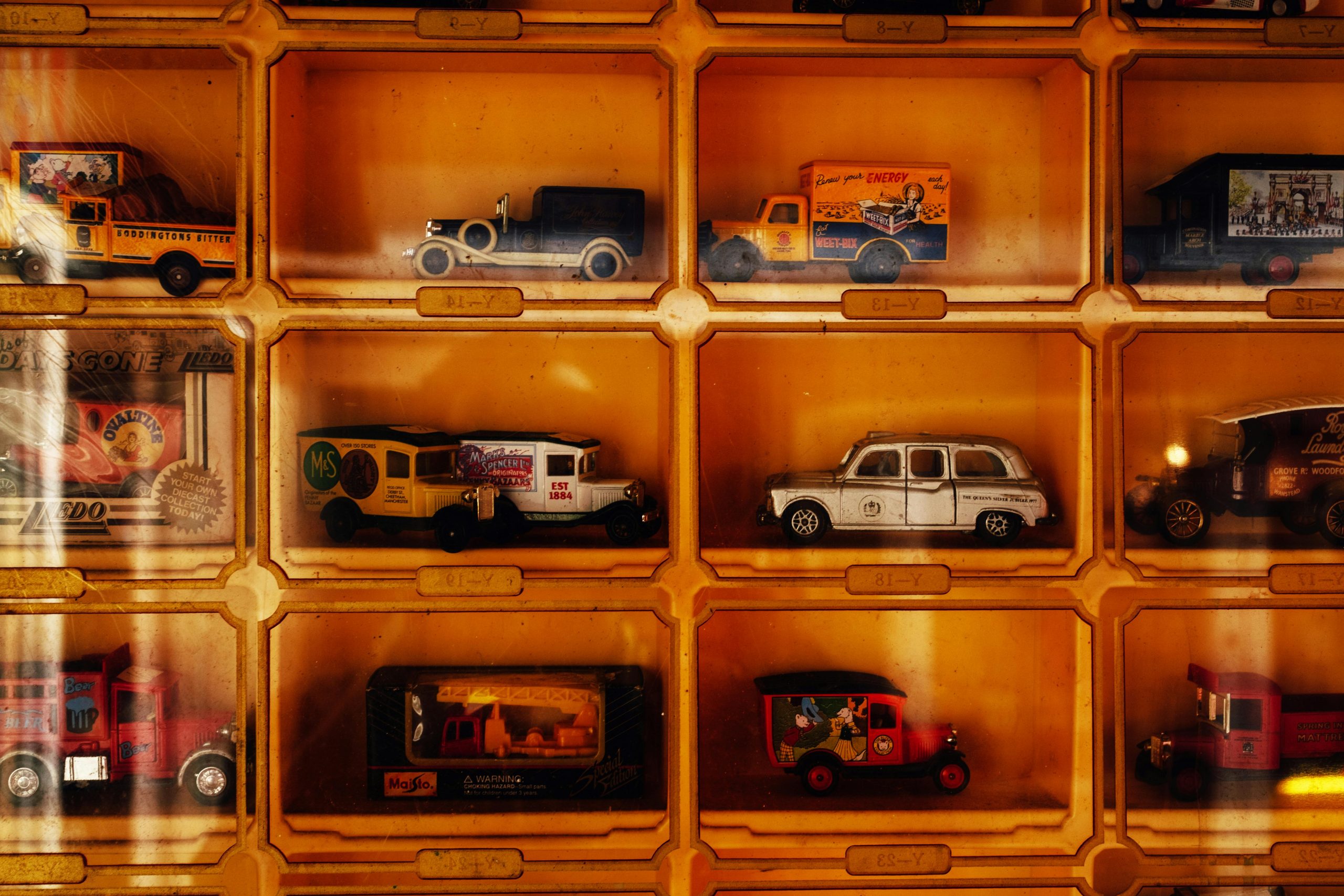 Showcase of vintage die-cast model cars in a display case, highlighting retro styles and nostalgia.